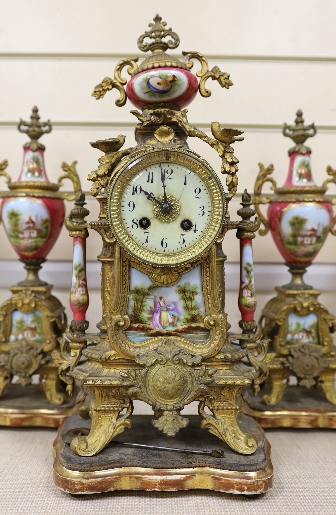 A 19th century Louis XV style gilt metal and porcelain mounted three piece clock garniture, clock 45cms high